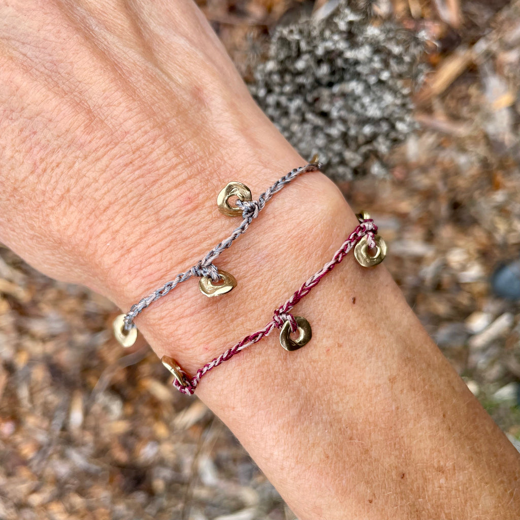 five charm ring bracelet on a two-color crocheted cord