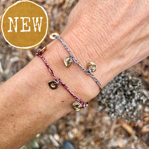 five charm ring bracelet on a two-color crocheted cord