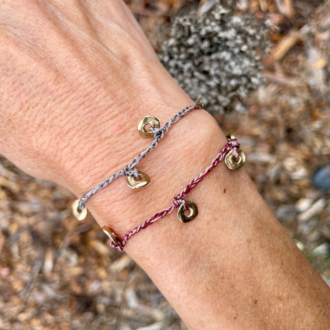 five charm ring bracelet on a two-color crocheted cord