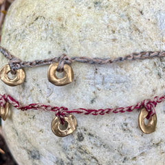five charm ring bracelet on a two-color crocheted cord