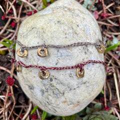 five charm ring bracelet on a two-color crocheted cord
