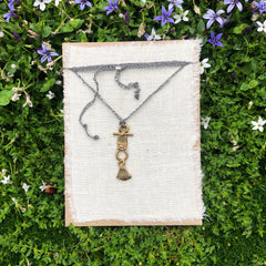 adjustable necklace: yellow bronze charm on slate grey crocheted cord