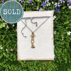 adjustable necklace: yellow bronze charm on slate grey crocheted cord