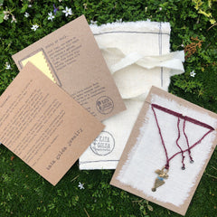 adjustable necklace: yellow bronze charm wrapped with indigo-dyed silk thread on burgundy crocheted cord