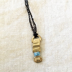 adjustable necklace: yellow bronze charm wrapped with indigo-dyed silk thread on dark brown crocheted cord