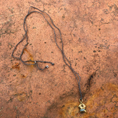 adjustable necklace: yellow bronze charm wrapped with indigo-dyed silk thread on slate grey crocheted cord
