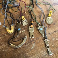 adjustable necklace: yellow bronze charm wrapped with indigo-dyed silk thread on dark brown crocheted cord